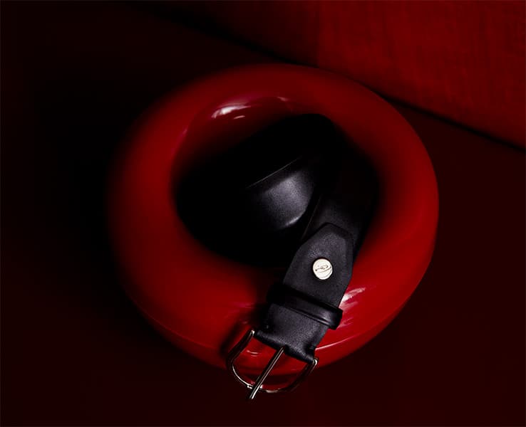 A picture of a Brioni belt on a red design piece