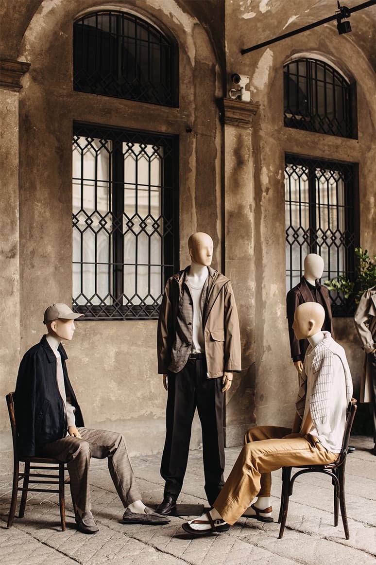 Mannequins displaying new SS26 Brioni Collection in earth tones against historic stone walls
