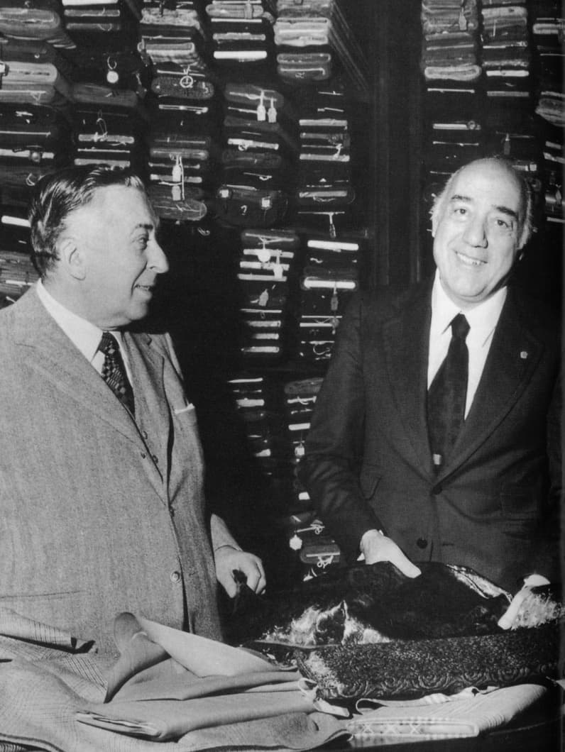 Brioni vintage black and white photo, with stacked boxes visible in the background.